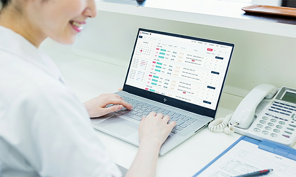 管理画面で患者の予約を管理するクリニックスタッフ