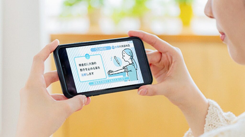 スマホで大腸検査の事前説明動画をみる患者の手元